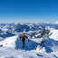 Bichlalm 2 Winter 2018-19-08880 Eine Skitourengeherin steigt in den Südbergen bei Kitzbühel einen verschneiten Hang hinauf, umgeben von alpiner Berglandschaft und blauem Himmel.