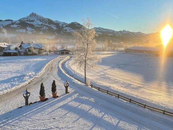 Aussicht Kitzbüheler Horn Verschneite Tallandschaft mit Blick auf das Kitzbüheler Horn bei Sonnenaufgang.