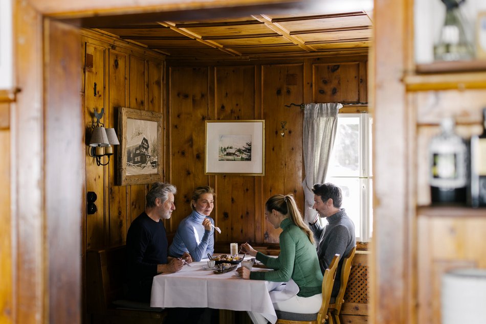 Ene Gruppe beim Essen nach dem Skifahren in einer gemütlichen Holzstube