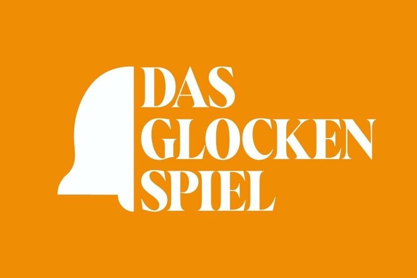 Weißes Logo mit Glockensymbol und dem Text DAS GLOCKENSPIEL auf orangefarbenem Hintergrund.