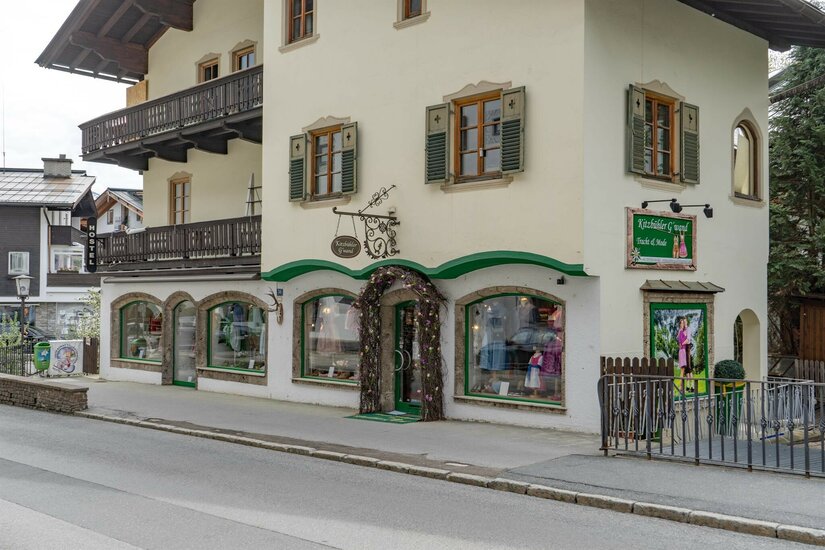 Kitzbühler Gwand Traditionelles Gebäude mit Trachtengeschäft im Erdgeschoss und Holzbalkonen.