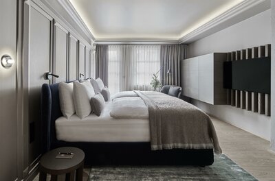 Modernes Hotelzimmer mit Doppelbett, Wandpaneelen und Fernseher.