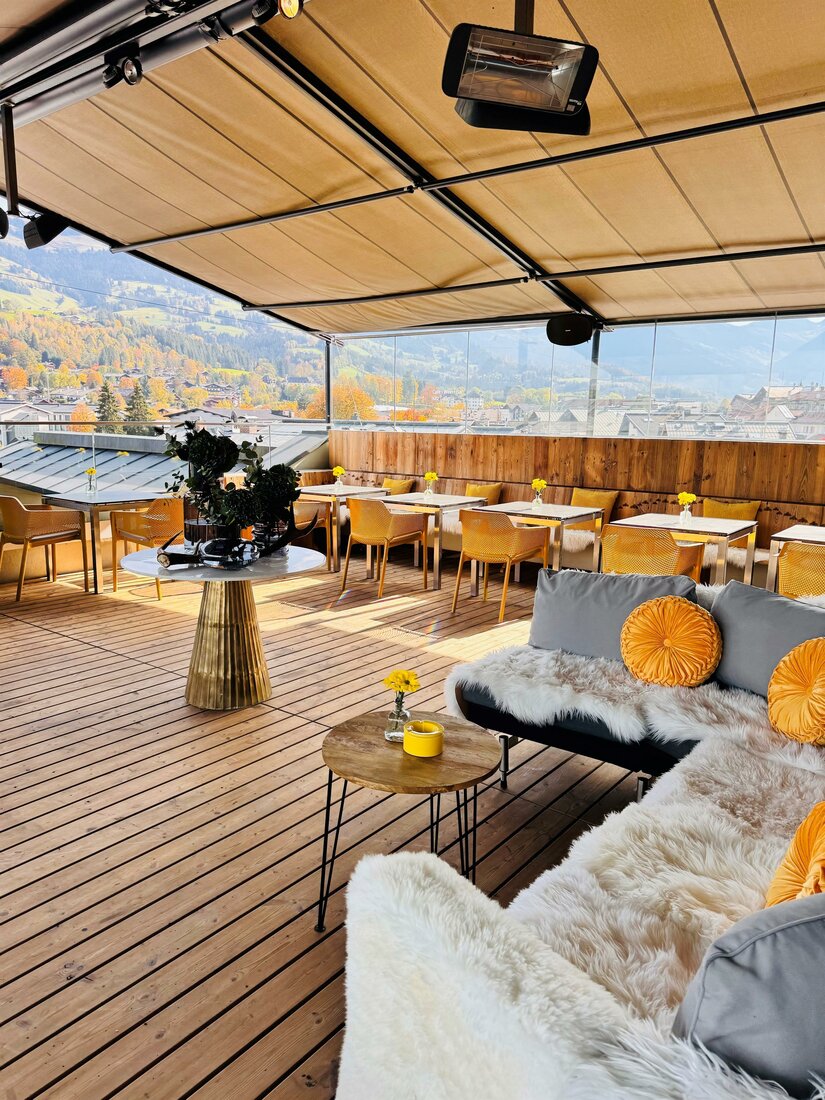 Eine moderne Terrasse mit gemütlichen Sitzgelegenheiten und einem schönen Ausblick auf die Landschaft. Die Einrichtung ist stilvoll und einladend, ideal für entspannte Stunden.