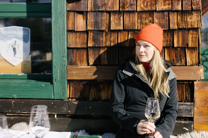 Woman having a glass of wine in the winter sun