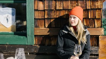 Woman having a glass of wine in the winter sun