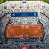 Eine Luftaufnahme des Tennisstadions bei den Kitzbüheler Meisterschaften, umgeben von Zuschauern und grüner Landschaft.