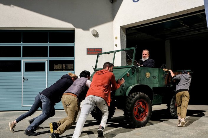 Personen schieben Fahrzeug