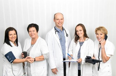 Team der Arztpraxis Dr. Hengl Fünf medizinische Fachkräfte in weißer Arbeitskleidung vor hellem Hintergrund.