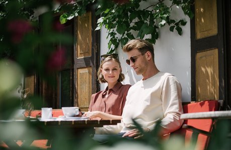 [Translate to EN:] Ein Pärchen im Kaffeehaus im Sommer