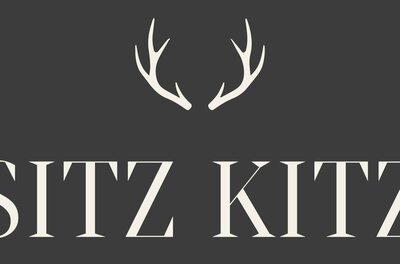 Sitz Kitz Logo Logo mit weißem Geweih-Symbol und dem Schriftzug SITZ KITZ auf dunkelgrauem Hintergrund.