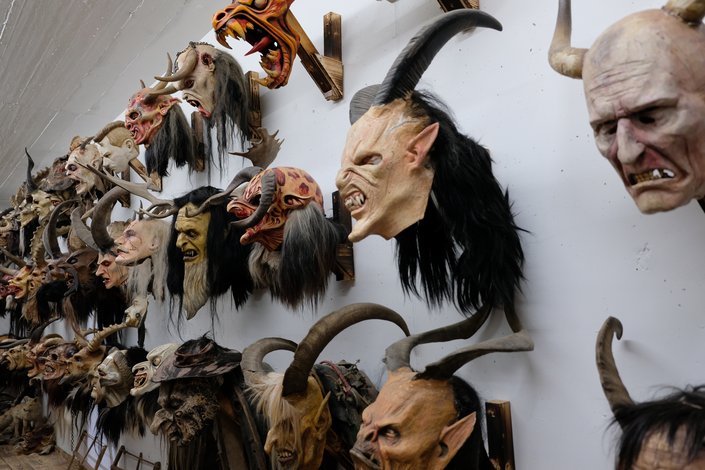 Mehrere Krampusmasken an einer Wand