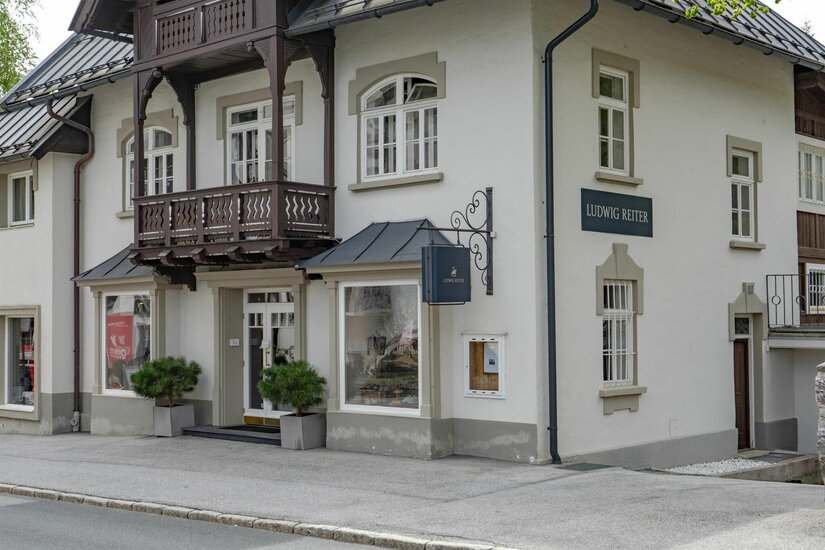 Außenansicht des Ludwig Reiter Geschäfts in einem traditionellen Gebäude mit Holzbalkon.