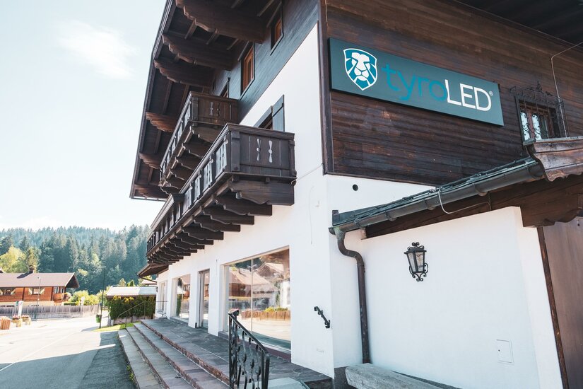Ein modernes Gebäude mit einem Balkon und einer großen Fensterfront. Das Schild "YARD LED" ist deutlich sichtbar.