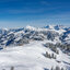 Eine schneebedeckte Winterlandschaft mit majestätischen Bergen und klar blauem Himmel, ideal für Skifahrer und Naturliebhaber.