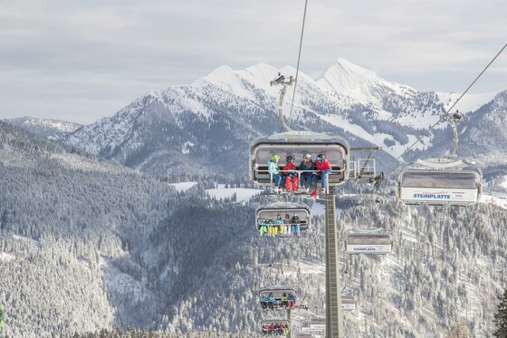 Skigebiet Steinplatte Eine Skiliftfahrt in den Bergen mit schneebedeckten Gipfeln im Hintergrund. Die Landschaft ist winterlich und idyllisch.