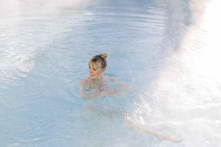 Eine blonde Dame schwimmt im Pool