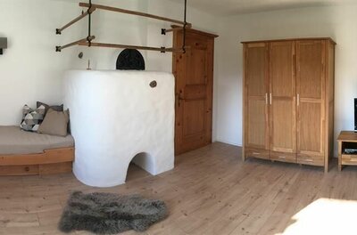 Wohnzimmer 4 Ein gemütlicher Raum mit einem Holztag, einem Kamin und einem Fernseher. Die Wände sind hell und die Möbel haben einen rustikalen Stil.
