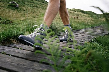 Bergschuhe und Holzweg 