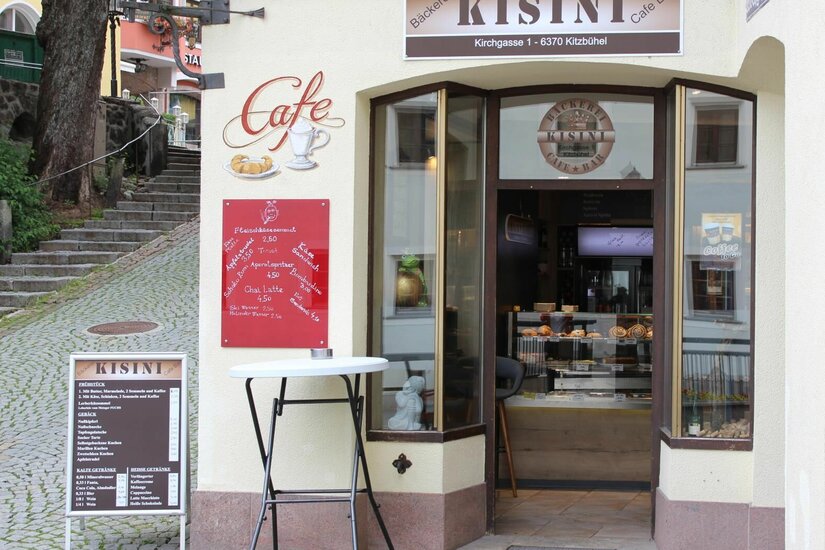 Bäckerei Kisini Kitzbühel Eingangsbereich der Bäckerei Kisini in Kitzbühel mit Menütafeln und Stehtisch.