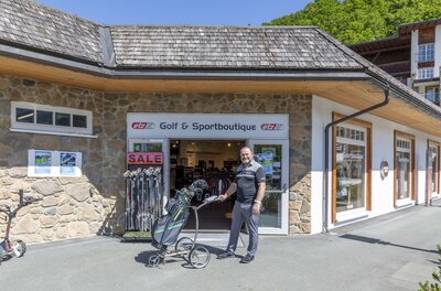 ETZ Golf & Sportboutique Ein Mann steht mit einem Golf-Trolley vor dem Eingang der ETZ Golf & Sportboutique.