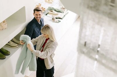 Einkaufserlebnis bei Kastenhuber Ein Paar betrachtet Kleidung und Schuhe in einem modern gestalteten Verkaufsraum.