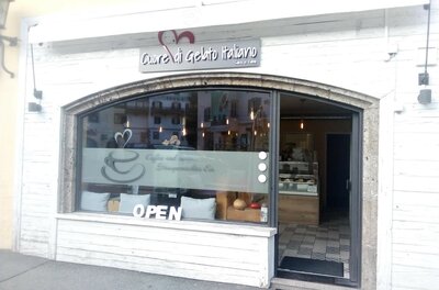 Eisdiele Cuore di Gelato Italiano Außenansicht einer italienischen Eisdiele mit weißer Holzfassade und großem Schaufenster.