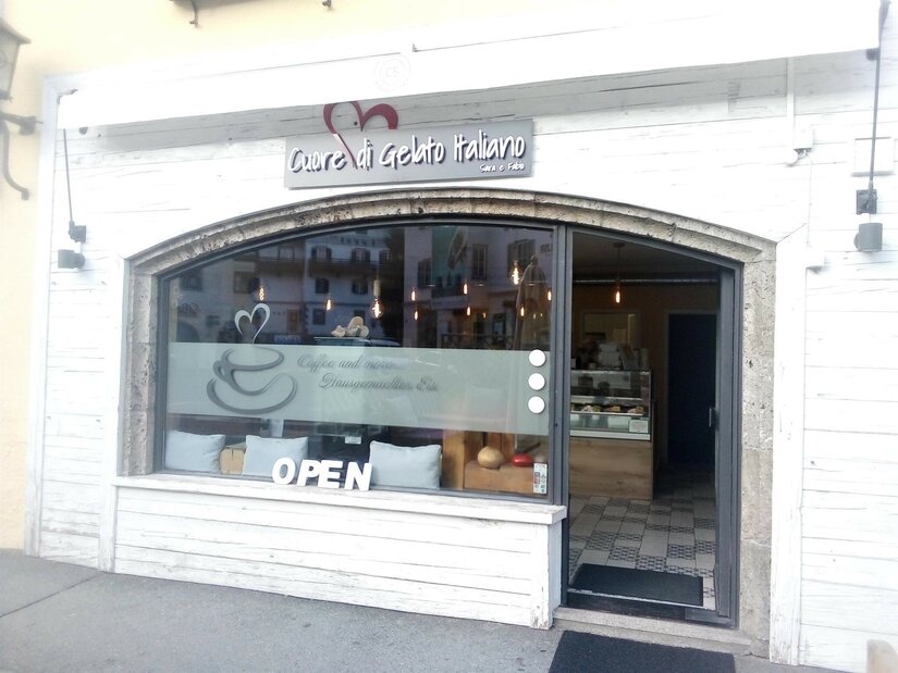 Eisdiele Cuore di Gelato Italiano Außenansicht einer italienischen Eisdiele mit weißer Holzfassade und großem Schaufenster.