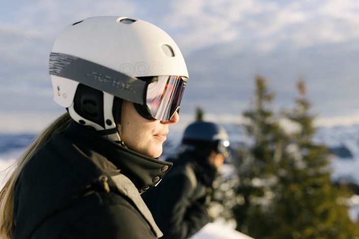 Eine Dame Closeup mit weißem Helm beim Skifahren