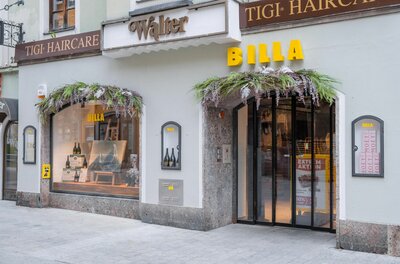 Billa Filiale Vorderstadt Eingangsbereich eines Billa Supermarktes in einem historischen Gebäude mit Blumendekoration über Tür und Schaufenster.
