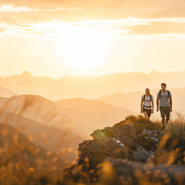 Two people are hiking at sunrise