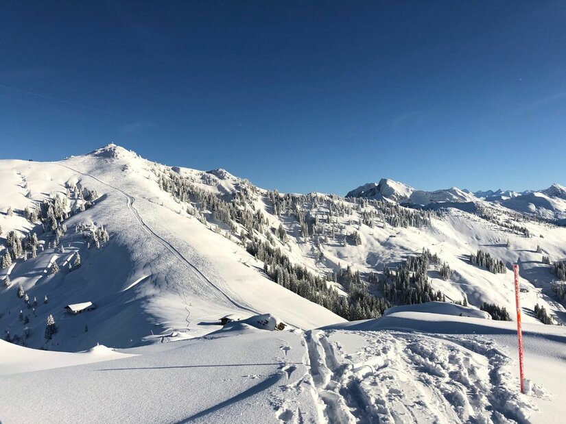 Hochetzkogel Panorama im Winter Verschneite Berglandschaft mit Skispuren im Vordergrund und Blick auf den Hochetzkogel unter blauem Himmel.