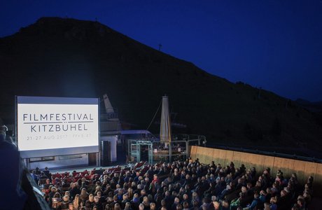 [Translate to EN:] Public Viewin mit großem Screen mit Bergen im Hintergrund