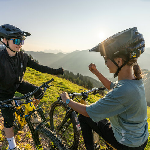On the 360 Flow Trails in Kitzbühel, two teenagers are playing rock-paper-scissors to decide who goes first.