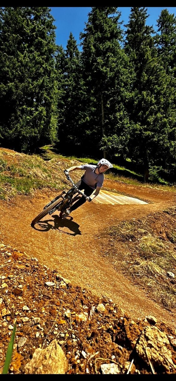 Mountainbiker auf dem Streiteck Trail Mountainbiker fährt eine Steilkurve auf einem Erdpfad im Wald.
