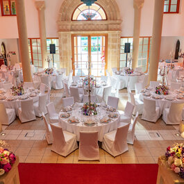 A castle hall furnished with seating and decorated for a meal