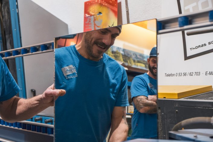 Zwei Männer in der Glaserwerkstatt vor einem Spiegel