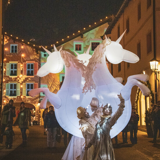 Street performer in a glowing unicorn costume on New Year's Eve in Kitzbühel