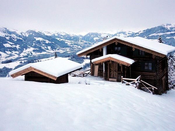 Berghütten Sonnschwendt im Winter Verschneite Holzhütte und ein Nebengebäude in einer alpinen Winterlandschaft mit Bergen im Hintergrund.