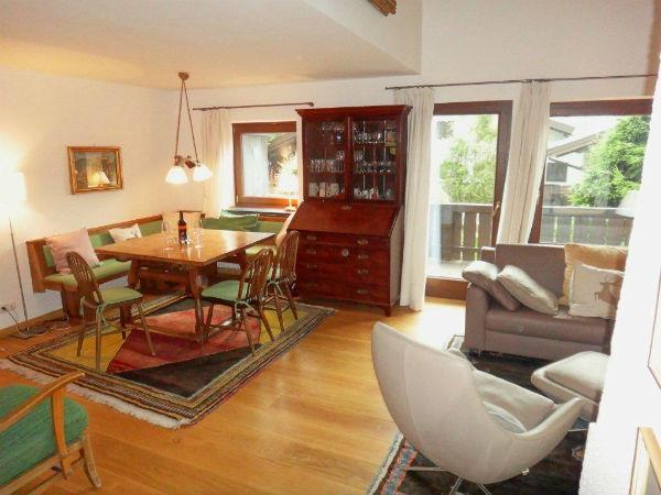 Wohn- und Esszimmer Haus Fleck Wohn- und Essbereich mit Holztisch, Eckbank, Sofa und einem dunklen Sekretär aus Holz.