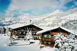 Hausbild Winter in Obernberg Zwei schneebedeckte Holzhäuser im alpinen Stil vor bewaldeten Berghängen im Winter.
