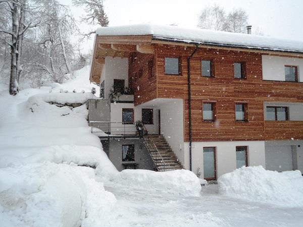 Winter am Genner Modernes Holzhaus mit Schneebedeckung im Winter.